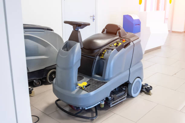 An operator using an autoscrubber machine on a commercial floor